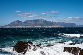 a large body of water with a mountain in the background