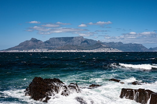 a large body of water with a mountain in the background