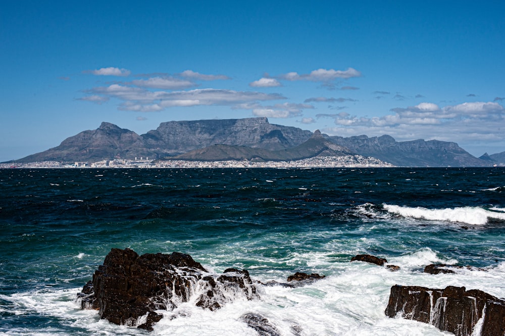 a large body of water with a mountain in the background