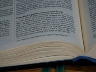 An open book displaying a page with text discussing Hezekiah's pride, success, and death. The page appears to be from a religious or historical text, with a focus on a narrative involving prayer and repentance.