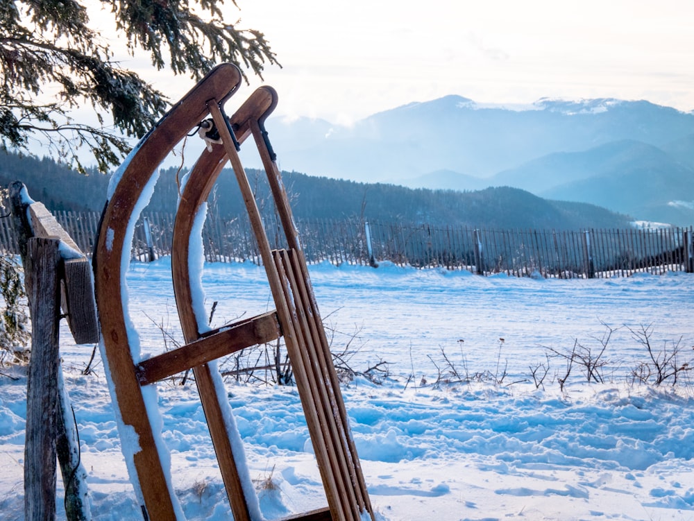 Ein Holzschlitten sitzt auf einem schneebedeckten Feld