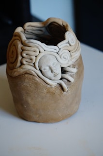 a ceramic sculpture of a head on a table