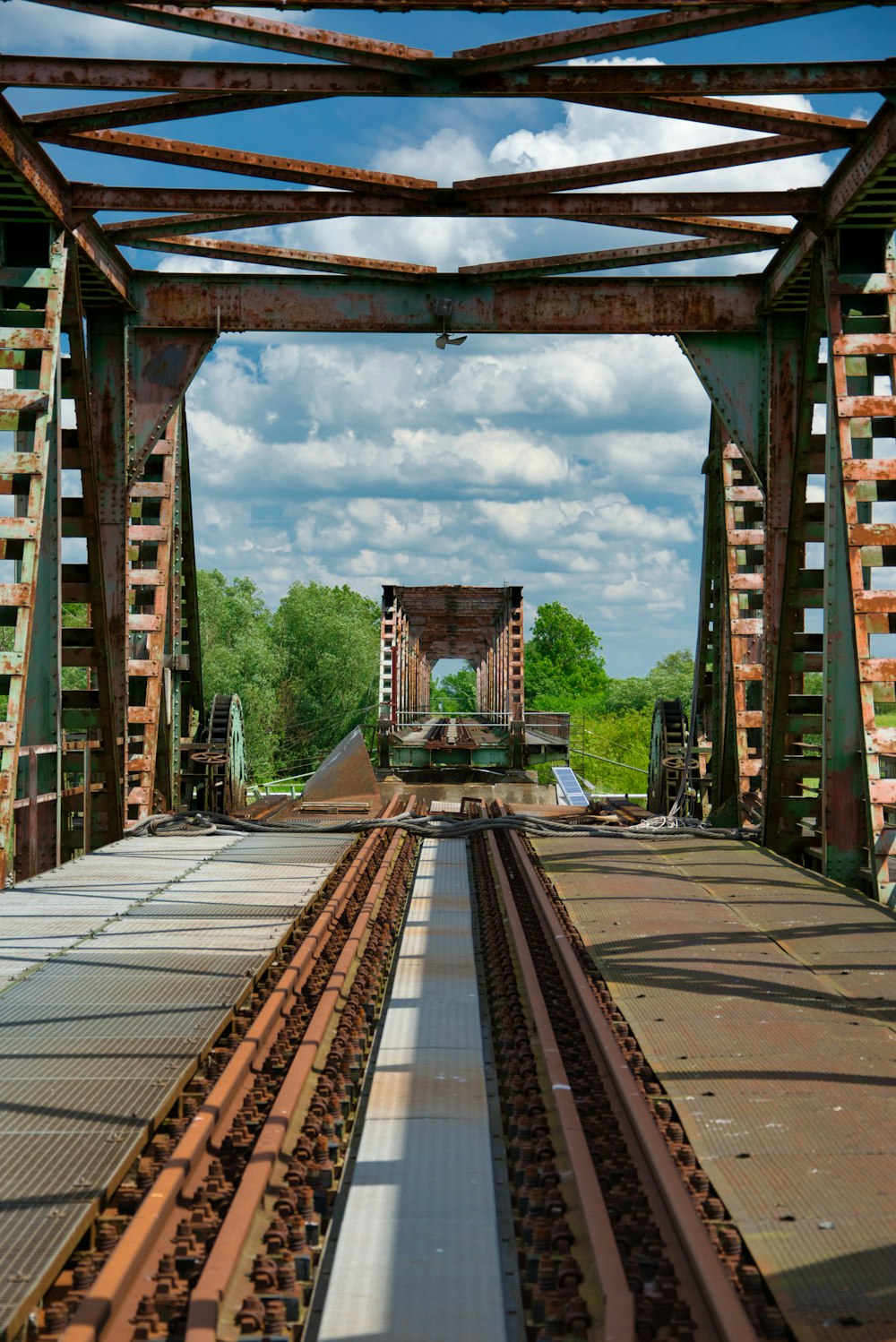 a train track going under a bridge on a sunny day