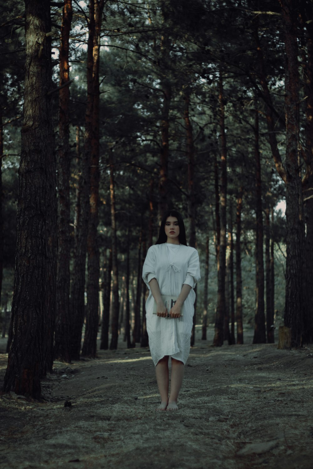 a woman standing in the middle of a forest