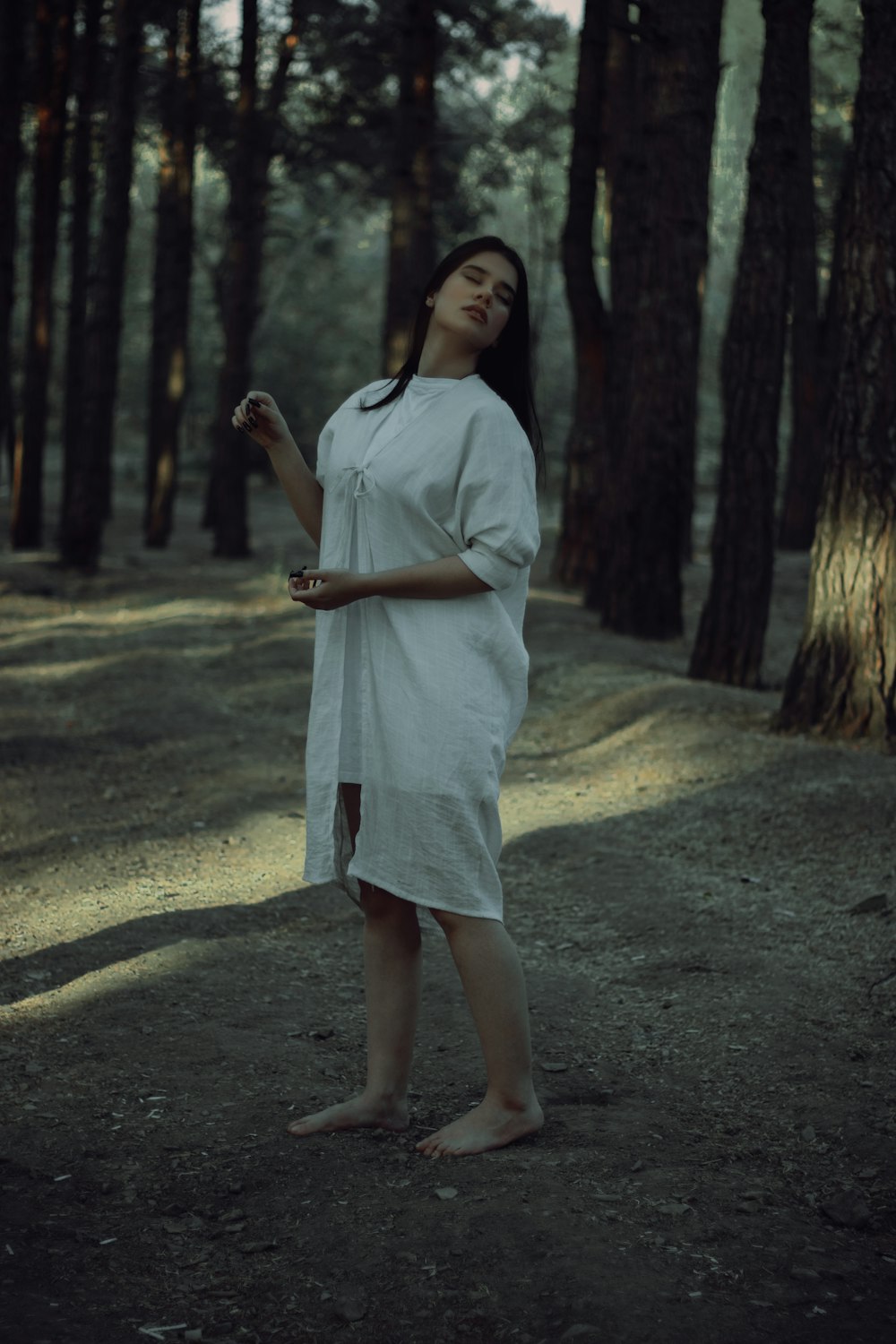 a woman standing in the middle of a forest