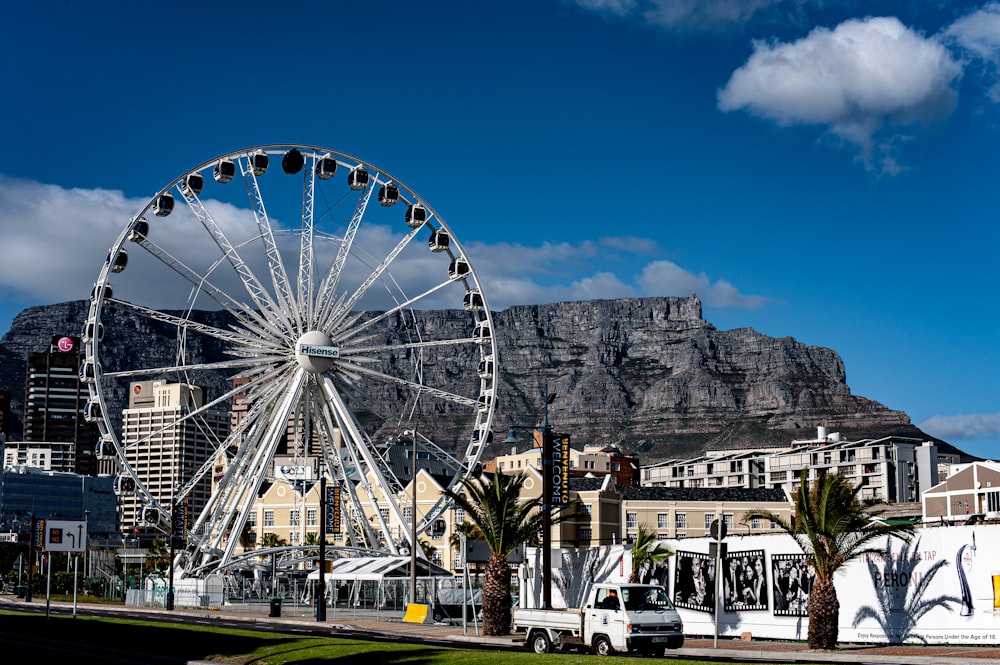 a large ferris wheel in front of a mountain