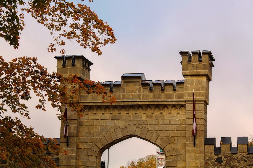 a stone gate with a clock tower in the background