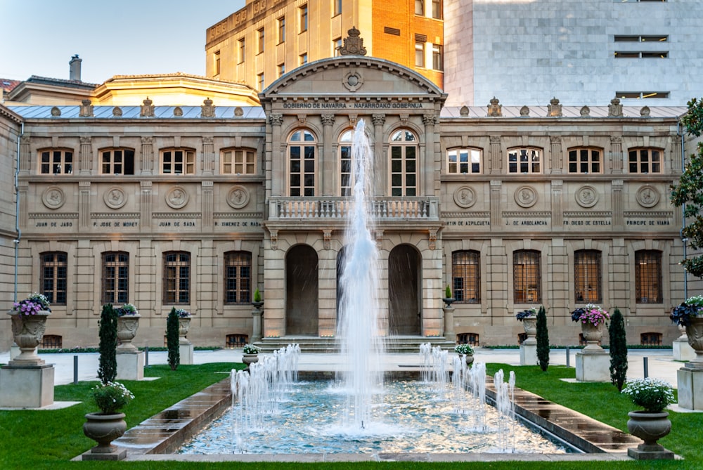 a large building with a fountain in front of it