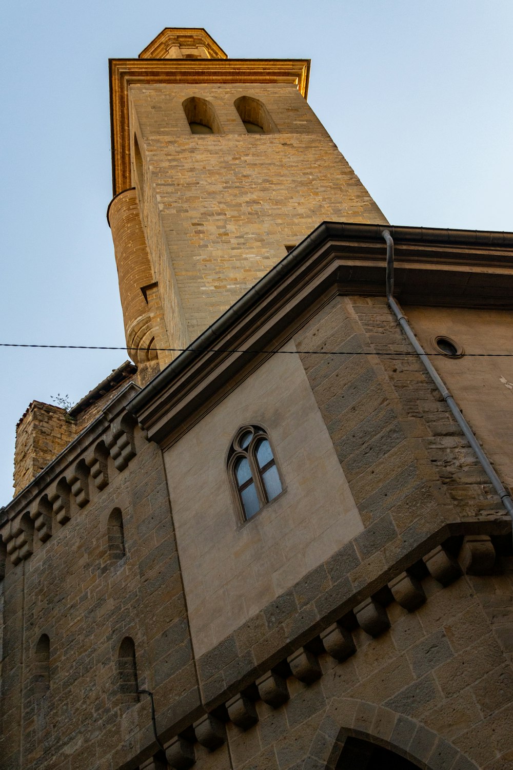 a tall brick building with a clock on it's side