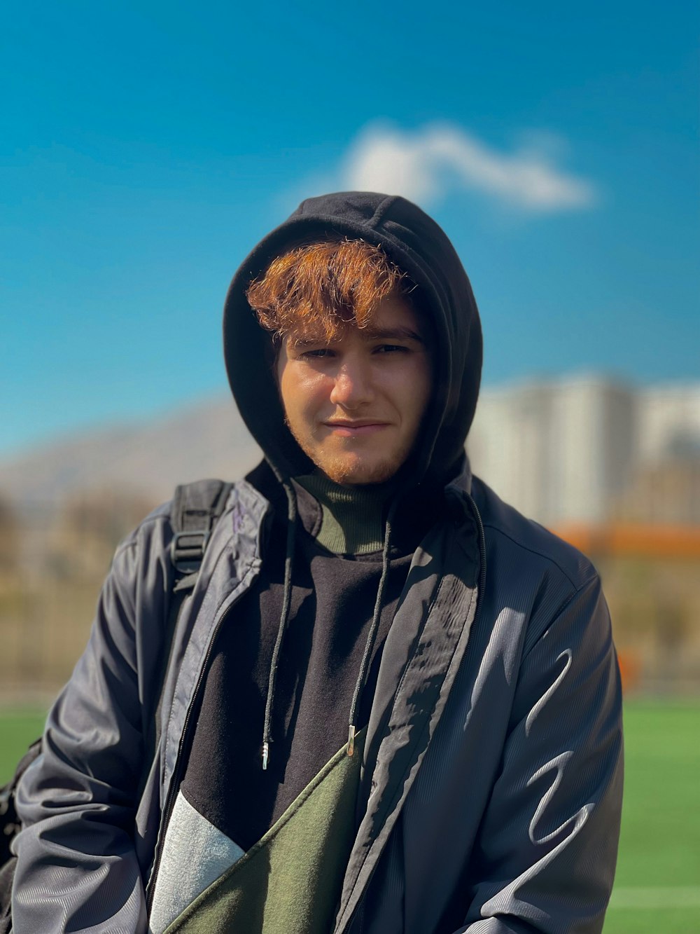 a man with red hair wearing a black jacket