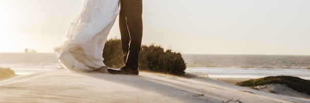 A bride and groom exchanging vows on a sunlit beach in Goa, with soft waves in the background.
