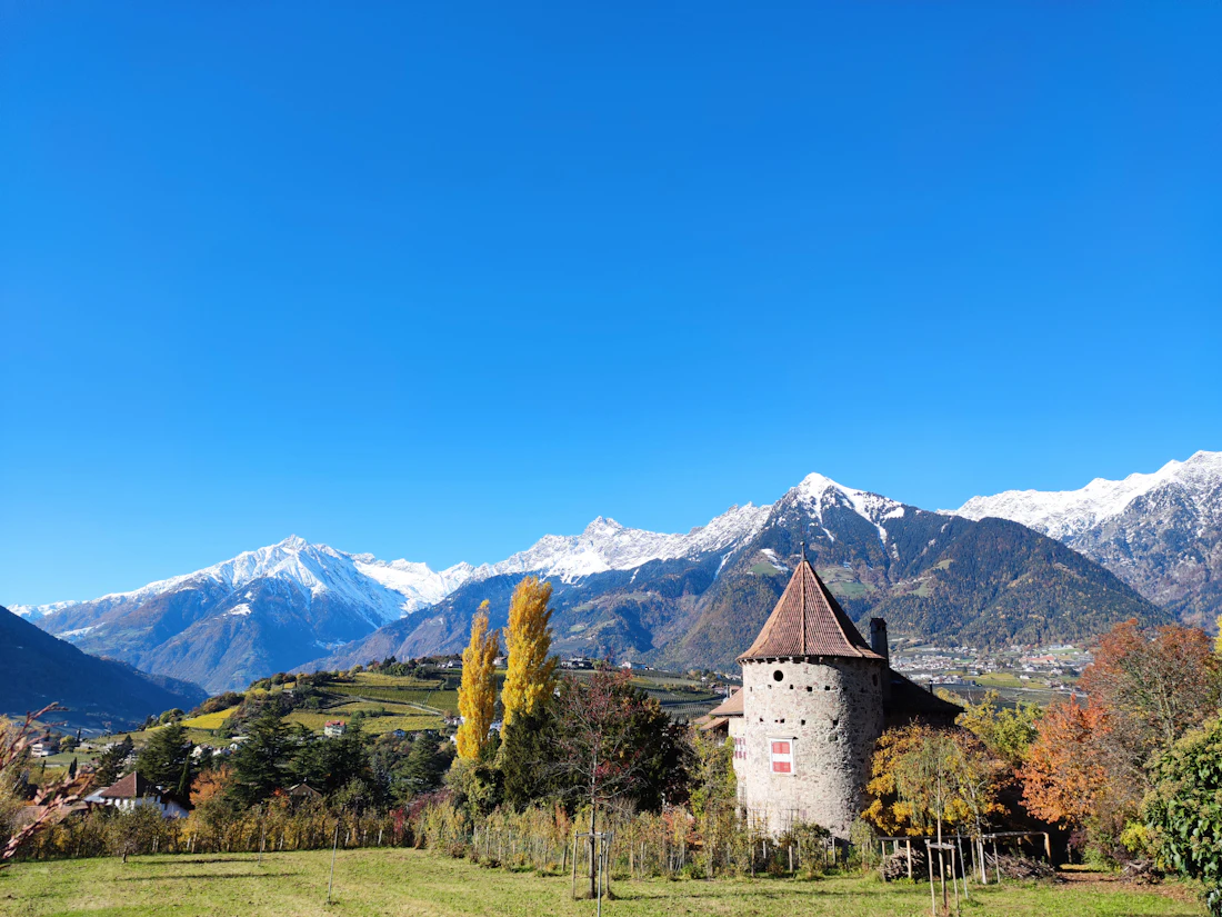 Kasteel in een veld met bergen op de achtergrond bij Merano