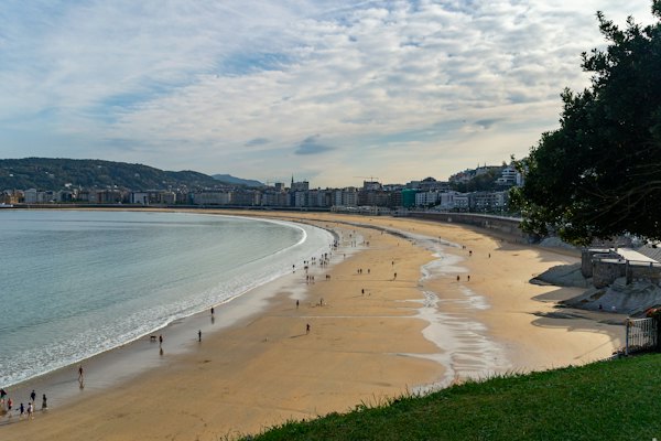 A sandy beach with people walking on it