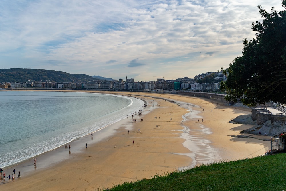 a sandy beach with people walking on it