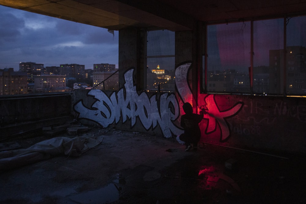 a person standing next to a graffiti covered wall