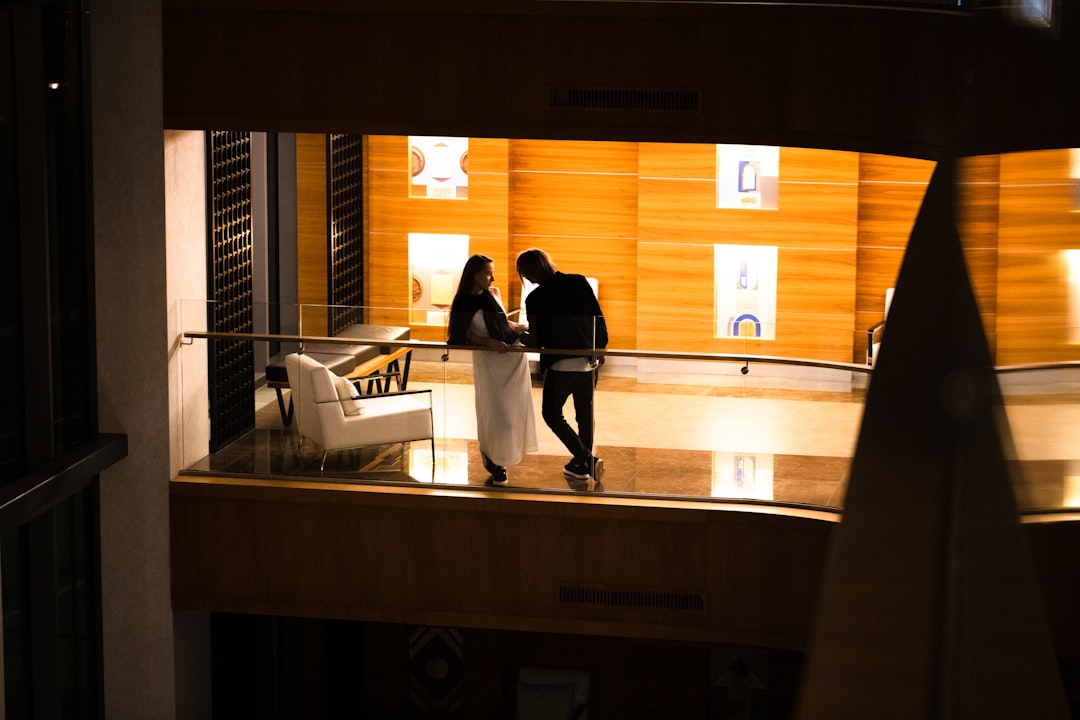 a man and a woman standing on a balcony at night,
