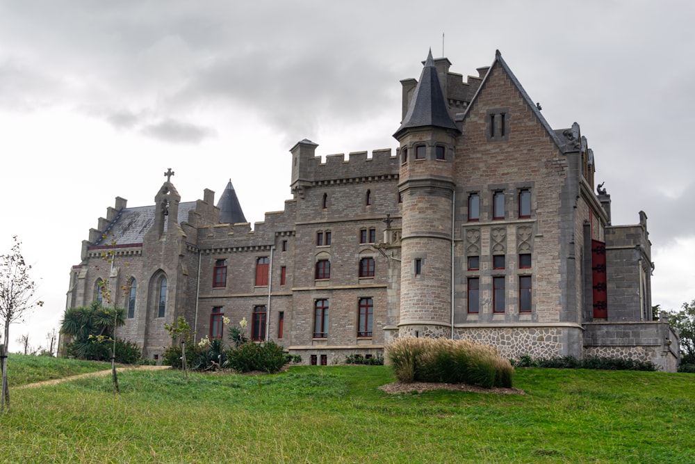 a large castle like building sitting on top of a lush green field