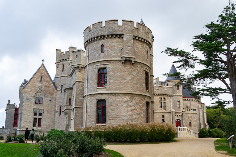 a large castle like building sitting on top of a lush green field