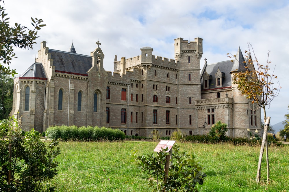 a large castle like building sitting on top of a lush green field