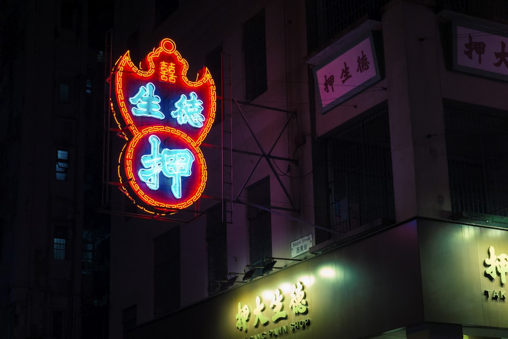 a sign on the side of a building lit up at night