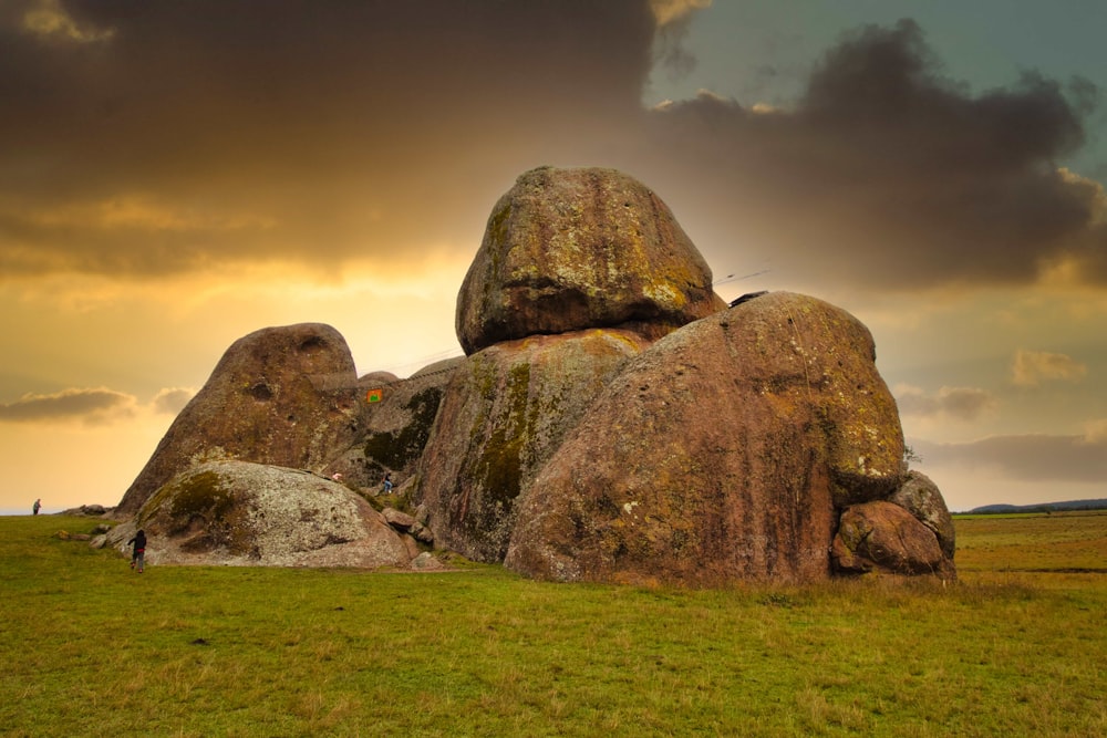 a large rock formation in the middle of a field