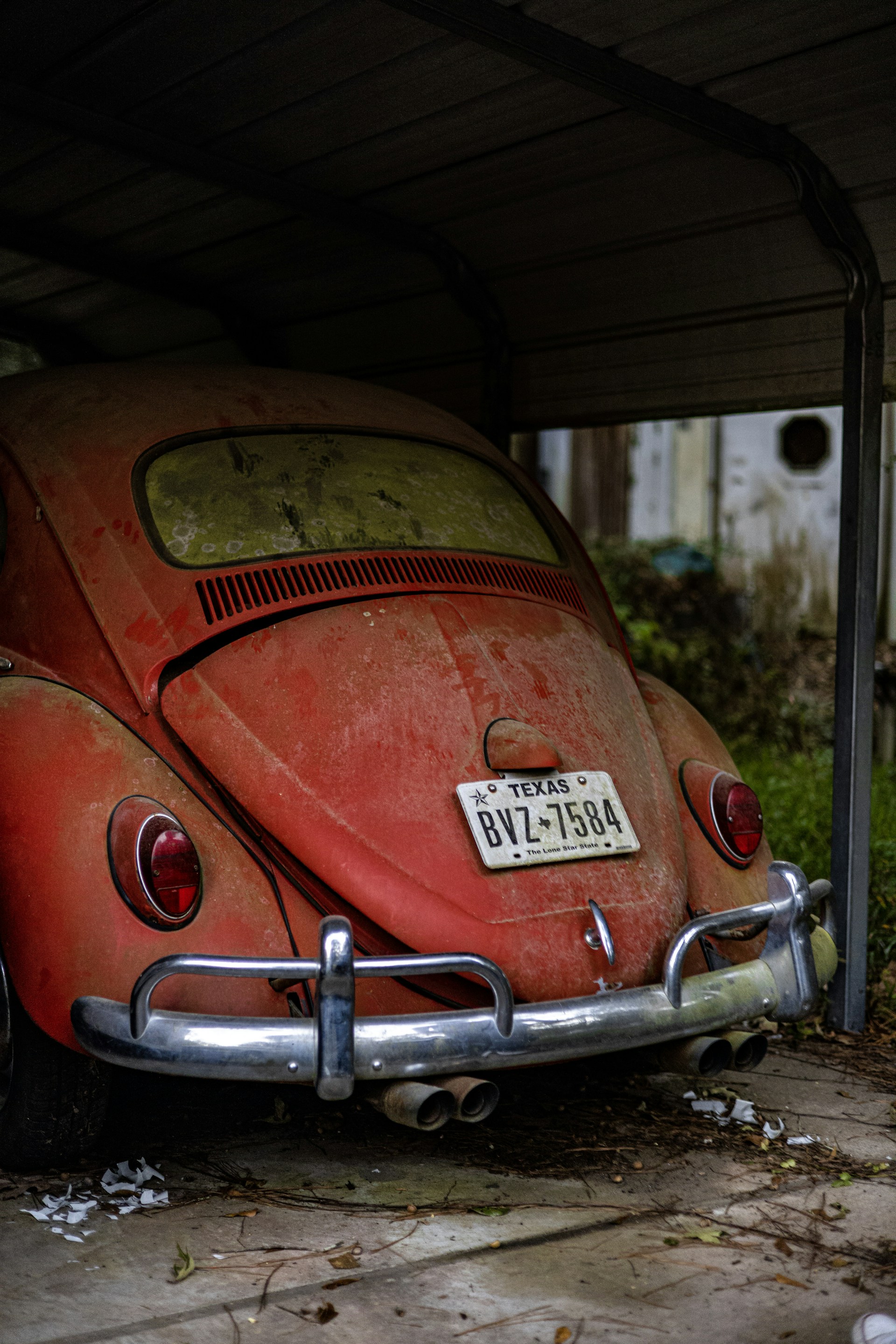 an old red vw bug parked in a garage