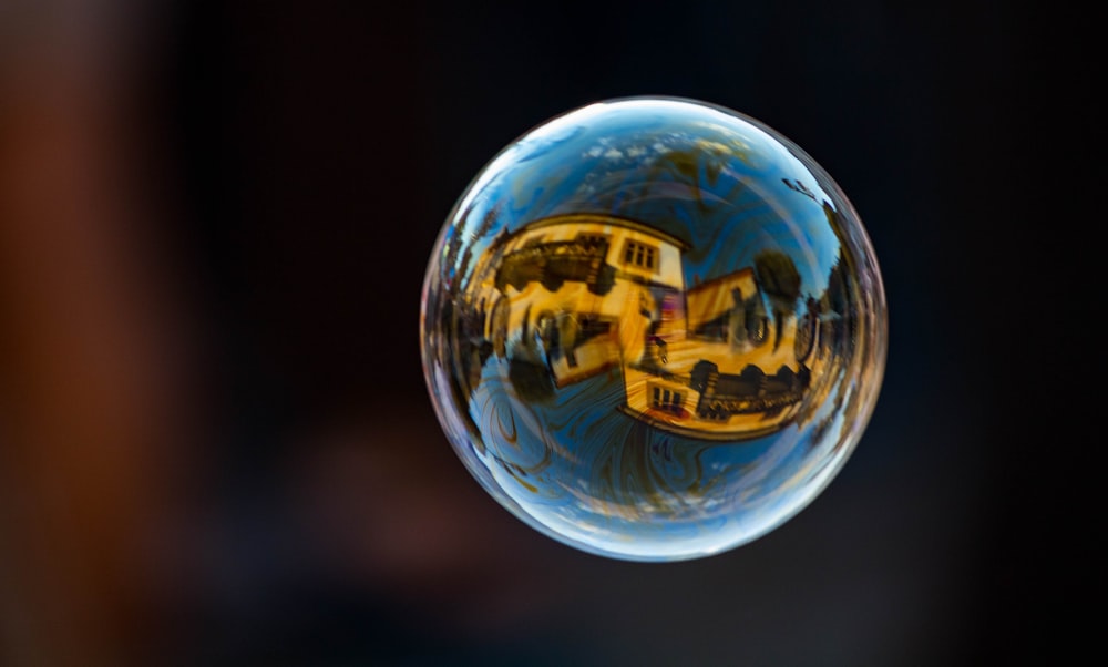 a close up of a glass ball with a reflection of a school bus