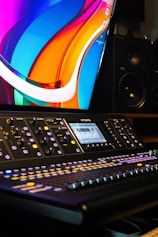 a sound mixing console with a monitor in the background