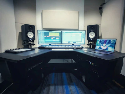 A vibrant studio setup with keyboards, speakers, and a laptop showing beat-making software