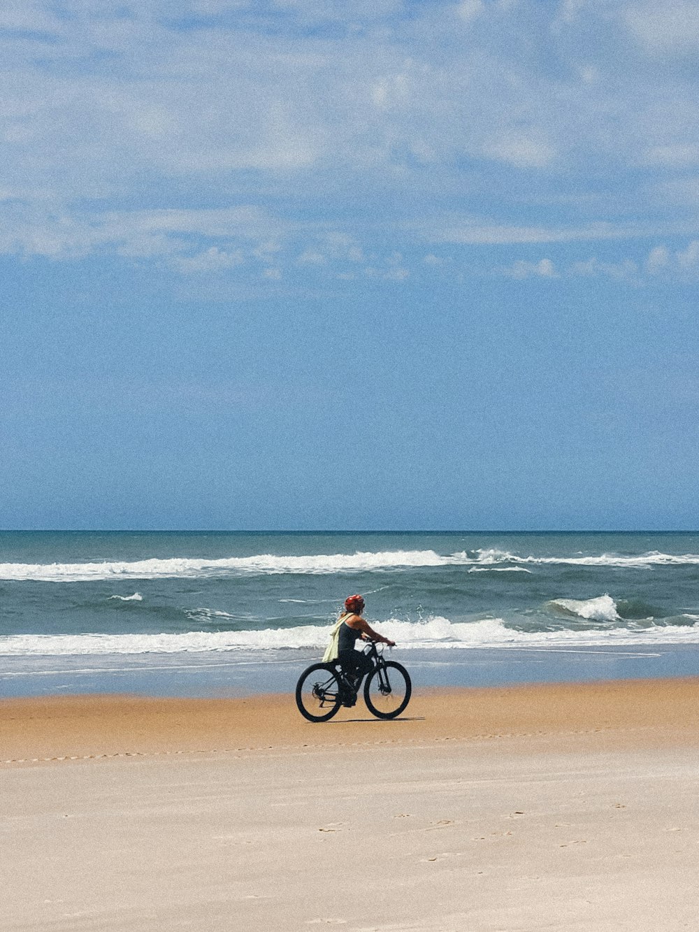 a person riding a bike on the beach