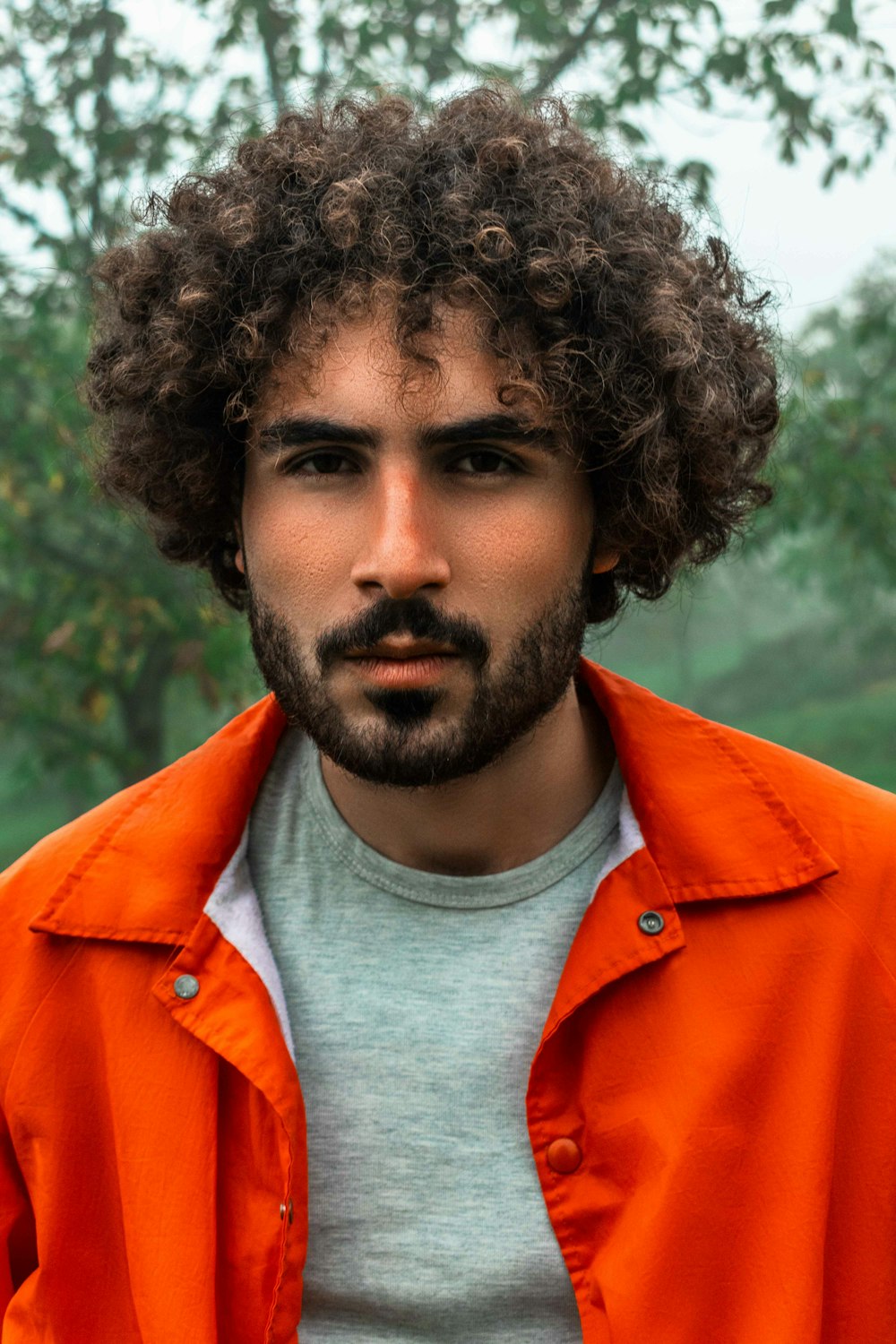 a man with a beard wearing an orange jacket