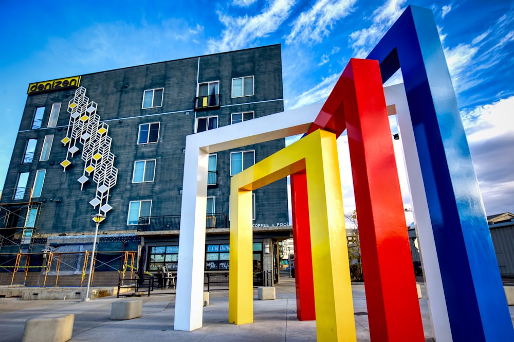 a multicolored sculpture in front of a building