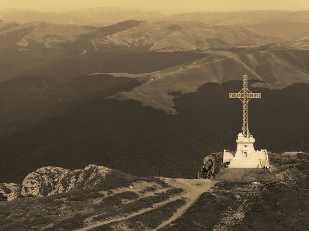 a cross on top of a mountain with mountains in the background