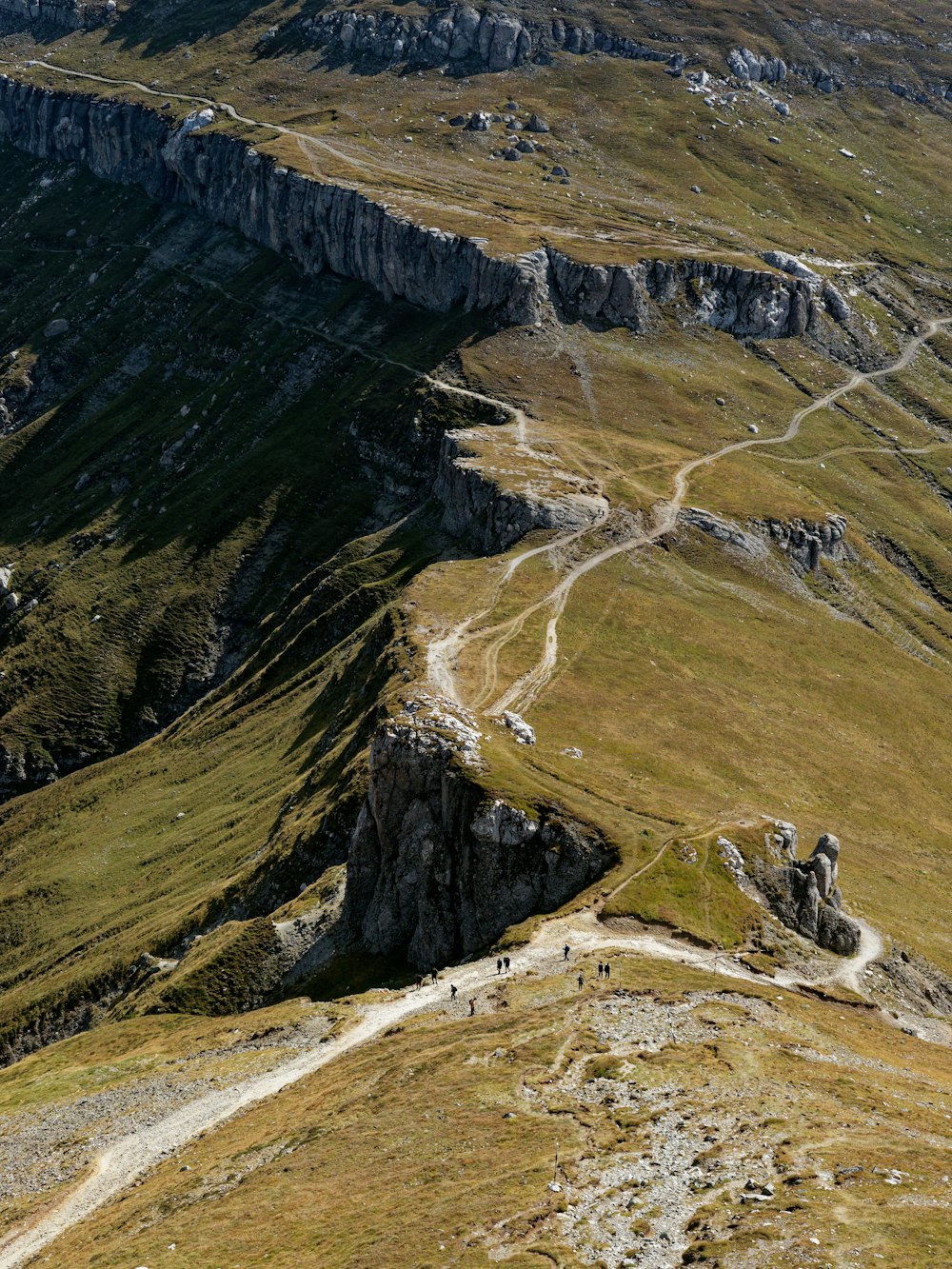 a group of people walking up the side of a mountain