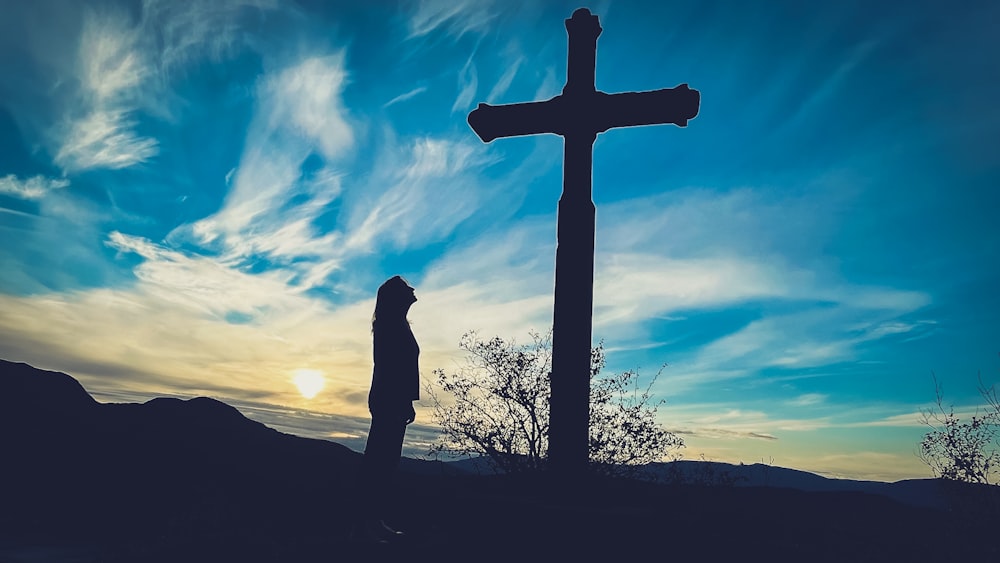 a person standing in front of a cross