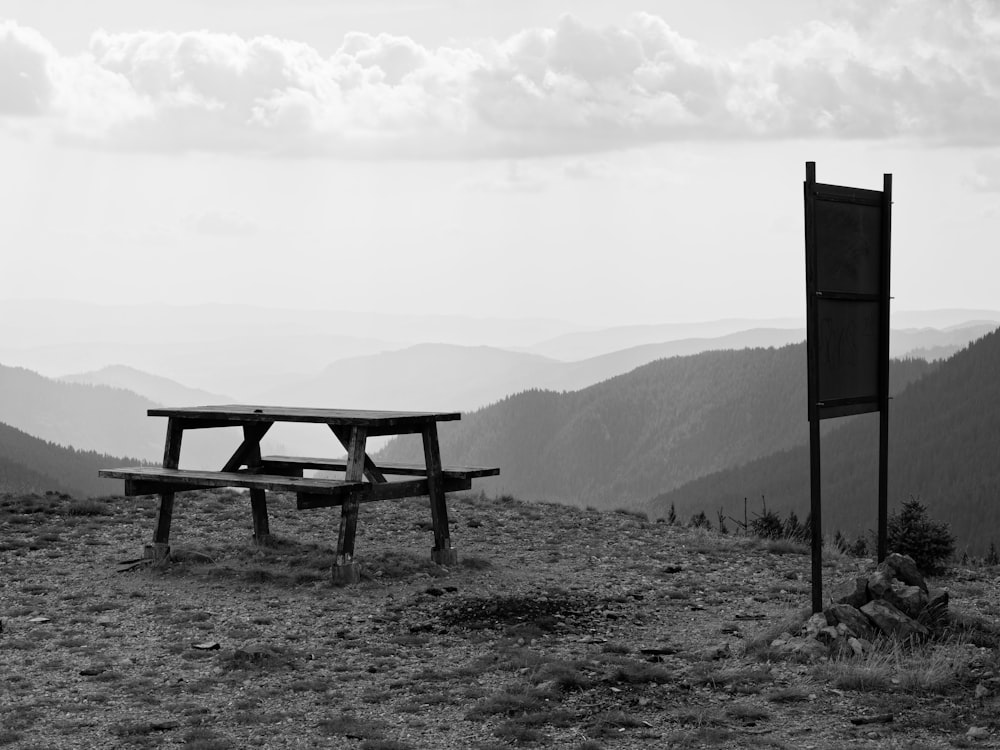 a wooden bench sitting on top of a grass covered hillside