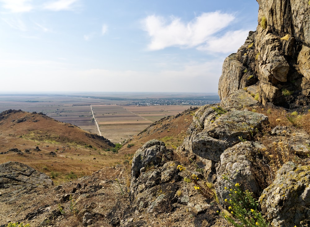 a rocky outcropping with a valley in the distance