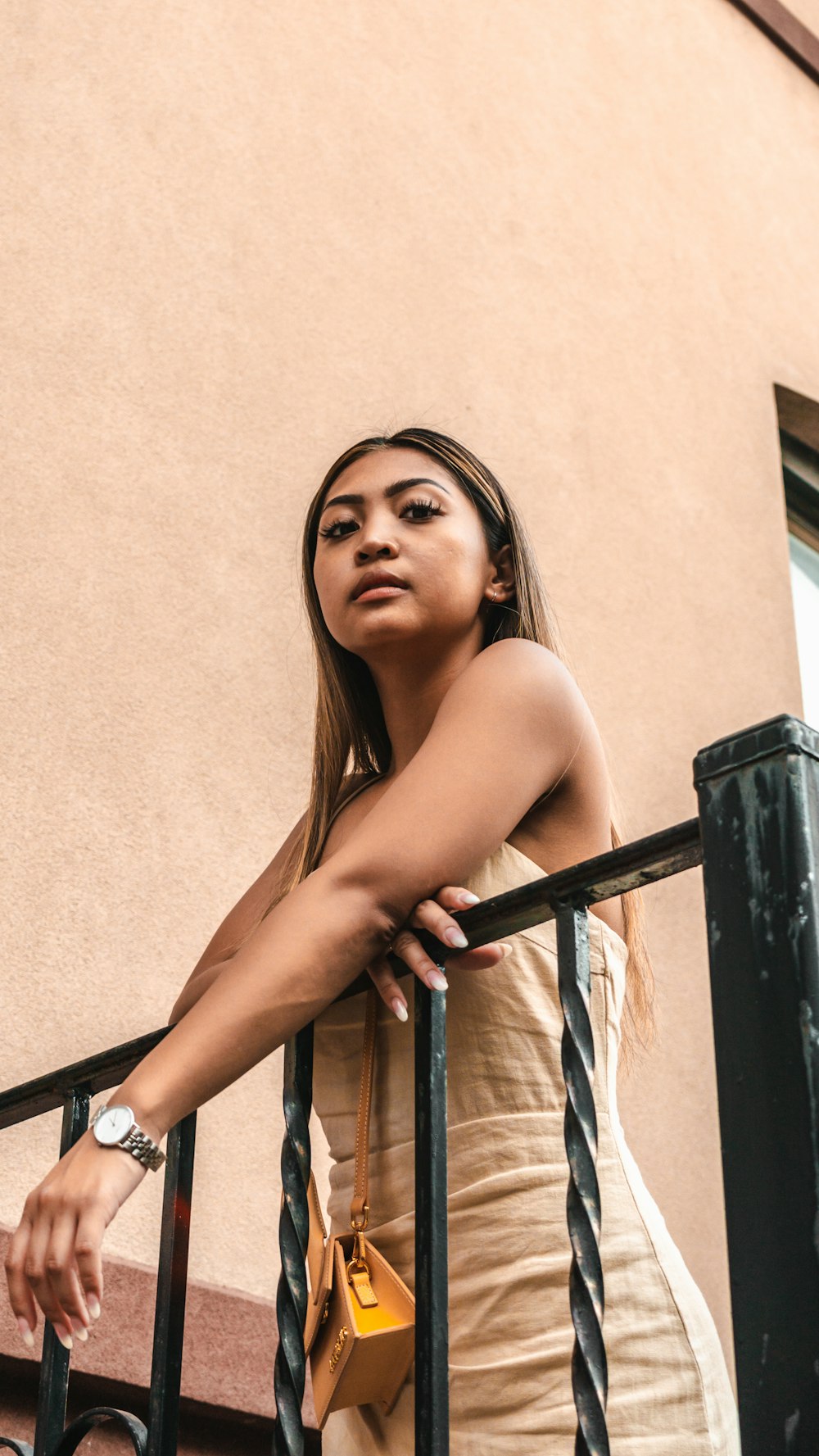 a woman standing on a balcony next to a building