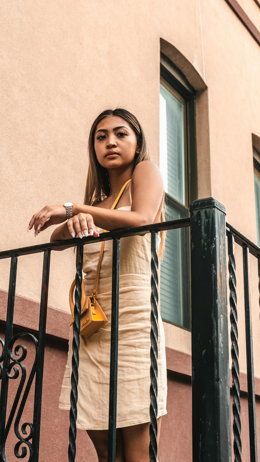 a woman standing on a balcony next to a building