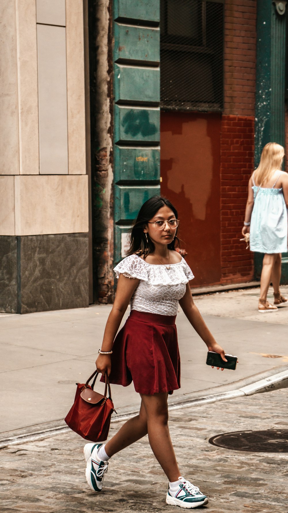 a woman walking down the street carrying a purse