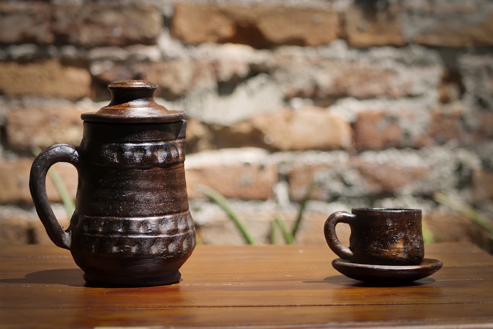 a wooden table topped with a brown coffee cup