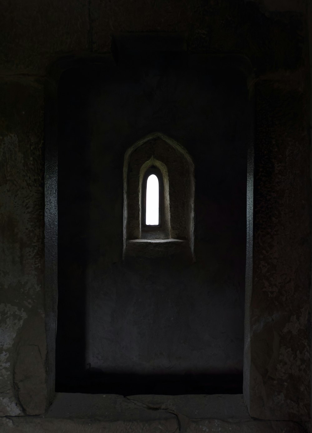 a dark room with a small window in it