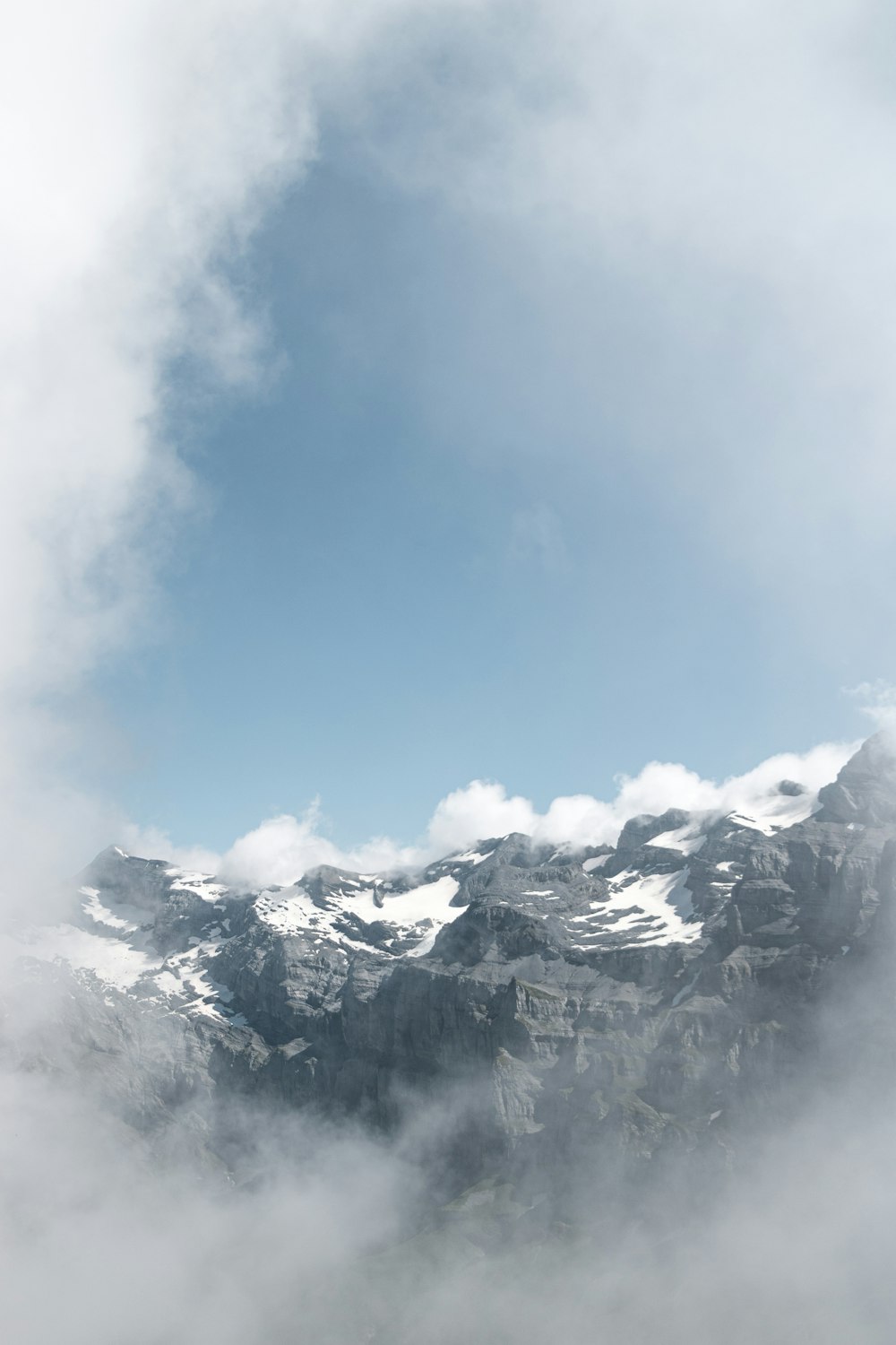 a view of a mountain range with clouds in the foreground