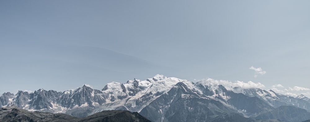 a mountain range with snow capped mountains in the background