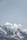 a snow covered mountain with a few clouds in the sky