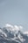 a snow covered mountain with a few clouds in the sky