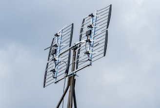 a television antenna on a pole with a sky background