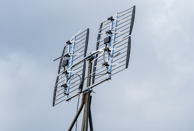 a television antenna on a pole with a sky background