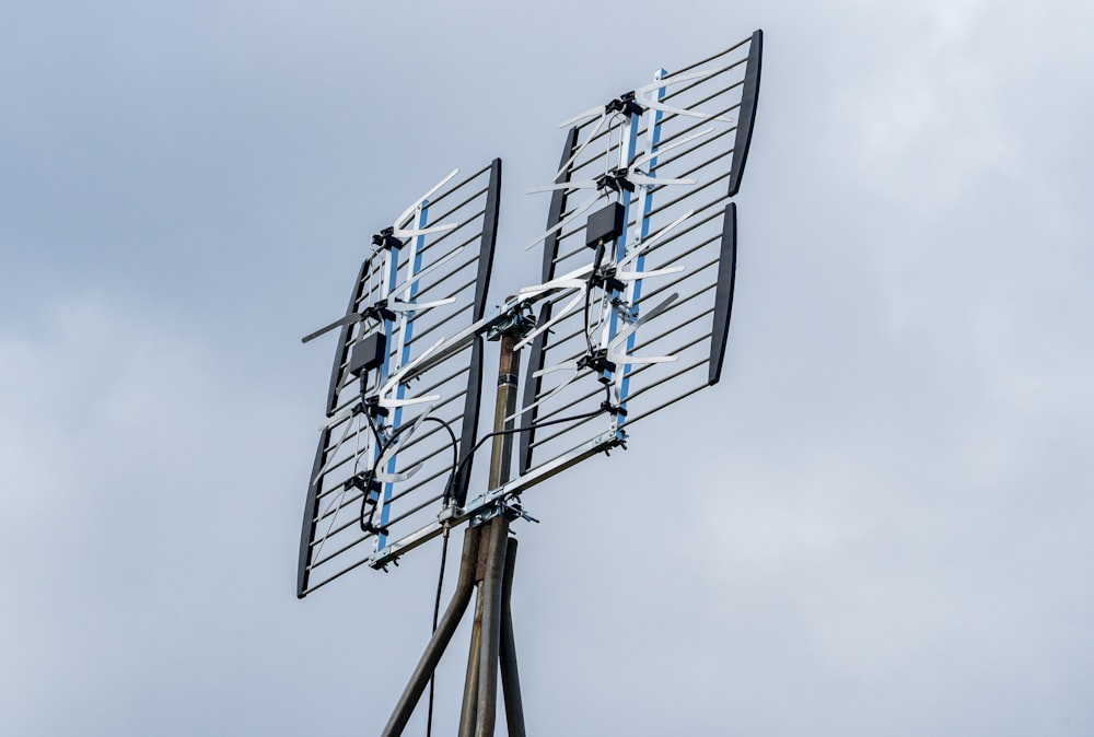 una antena de televisión en un poste con un fondo de cielo