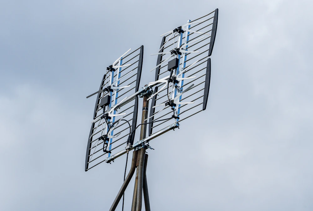 Realigned rooftop TV aerial against a clear sky